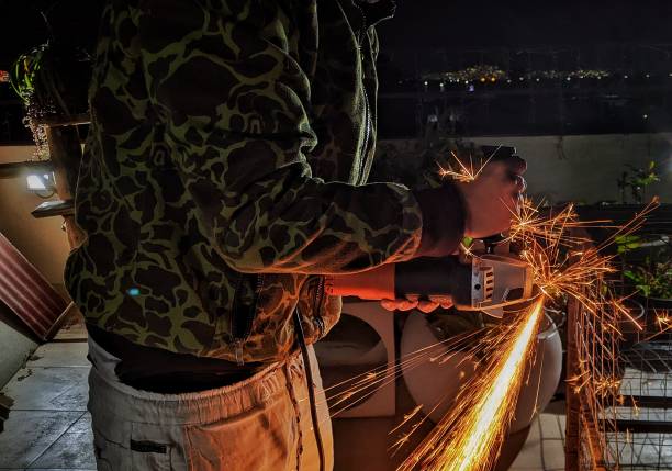 latino blacksmith making sparks while working concentrated