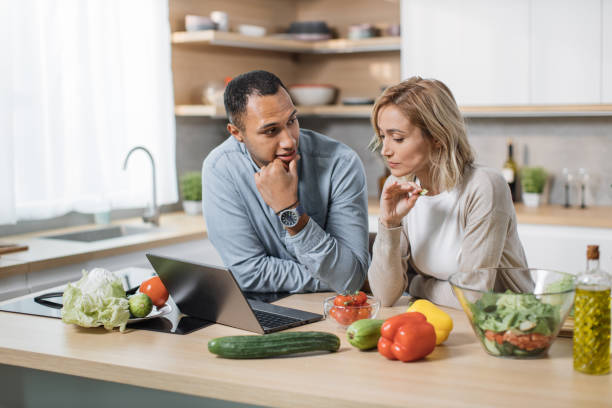 istock Happy young multiracial couple using laptop computer preparing healthy food diet vegetable salad 1433894338