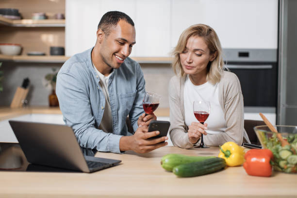 istock Smiling young spouses having delicious healthy breakfast together and using cell phone 1433896094
