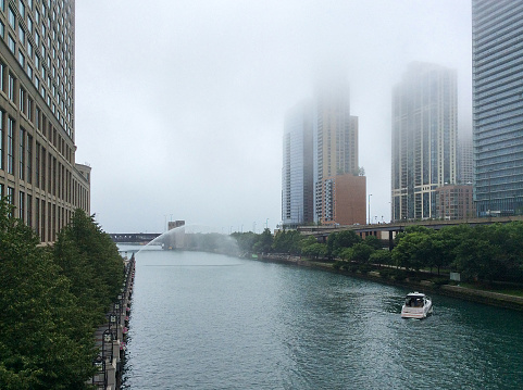 High-rise buildings on the banks of the river, city waterfront in Chicago, USA. City landscape in the fog.