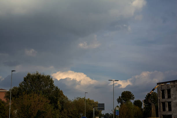 Cloudy  sunset sky framed by trees and a building
