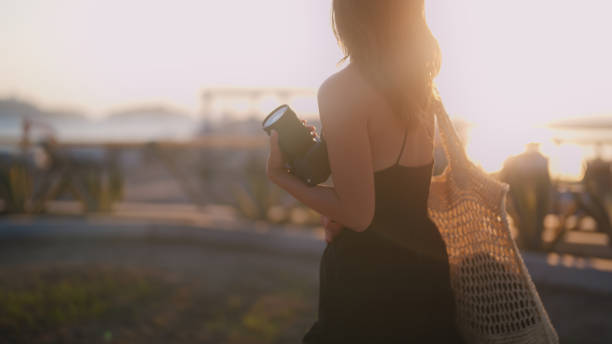 junge touristin bei einem spaziergang am hafen während des sonnenuntergangs - activity asia atmosphere beach stock-fotos und bilder