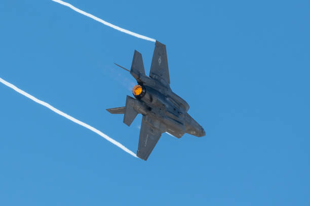 Lockheed Martin F-35B Lighting II Turns under high G maneuver creating wing tip contrails. Fighter airplane banking in sky with white wing tip trails. Photo taken in non ticket area Miramar Airbase in San Diego California USA on September 23, 2022. fa 18 hornet stock pictures, royalty-free photos & images