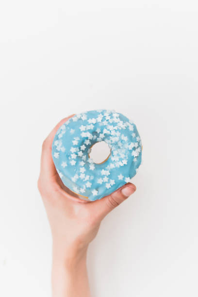 istock Left hand holding a delicious blue donut. 1433916717
