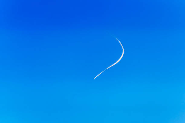 Inversion trail of a curved aircraft in a blue sky