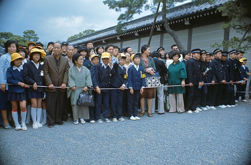 Tokyo, Honshu, Japan, 1978. Curious onlookers behind a safety rope during a state visit to a Tokyo Shinto shrine.