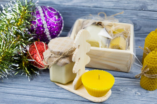 Christmas composition from a gift box with gold and silver Christmas balls and a white Christmas tree candle.