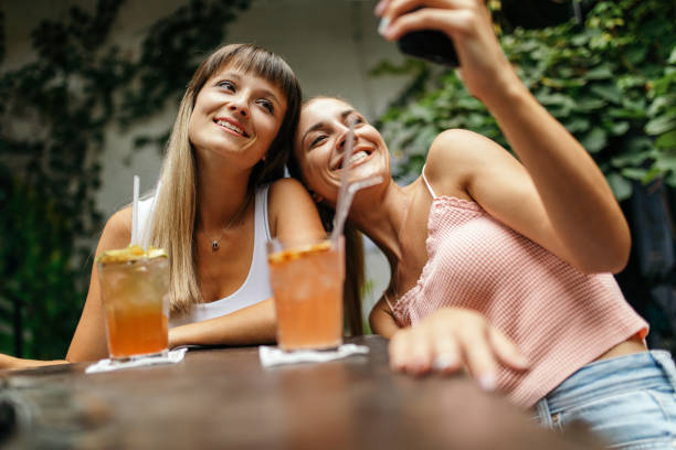 istock Two young women enjoying together while drinking cocktails 1433921871
