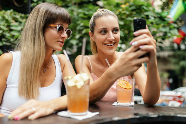 istock Two young women enjoying together while drinking cocktails 1433921943