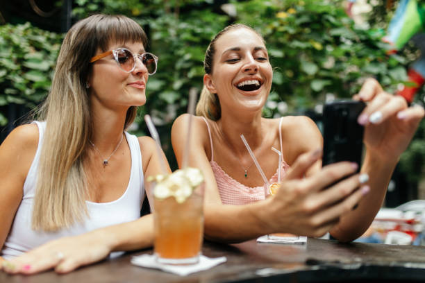 istock Two young women enjoying together while drinking cocktails 1433921979