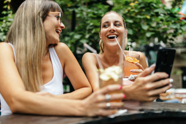 istock Two young women enjoying together while drinking cocktails 1433921984