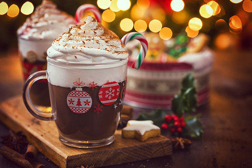 Two cups of hot chocolate with whipped cream and candy cane for the Christmas