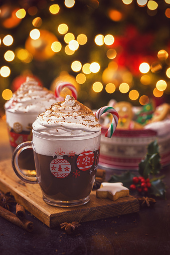 Two cups of hot chocolate with whipped cream and candy cane for the Christmas