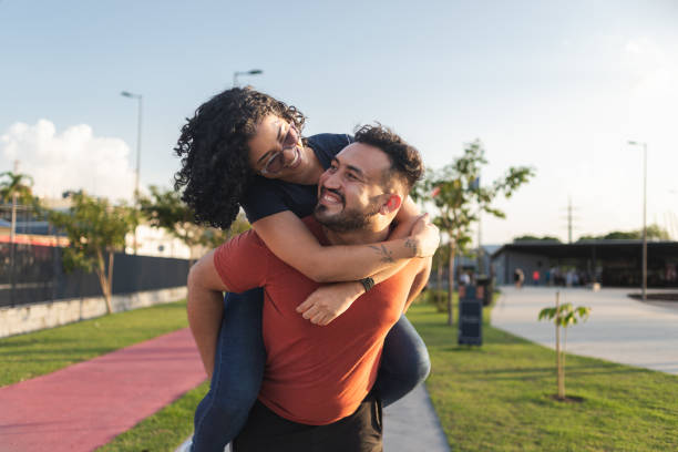 istock Man piggybacking his girlfriend in a public park 1433937500