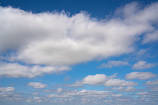 White cumulus clouds in a blue summer sky background