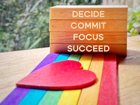 Inspirational and Motivational Concept - DECIDE COMMIT FOCUS SUCCEED text on wooden blocks background. Stock photo.