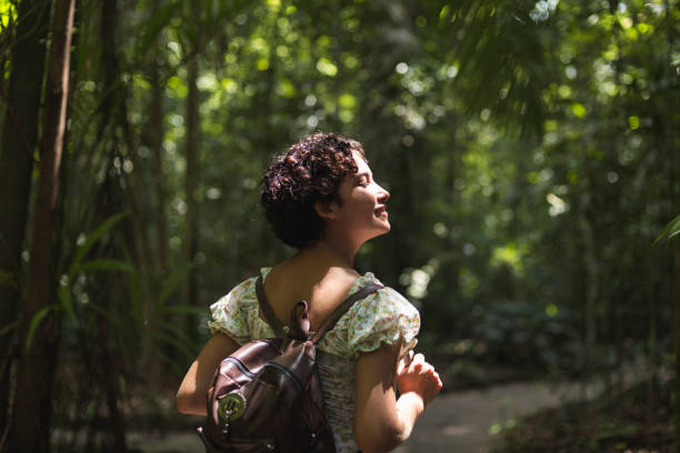 istock Young woman walking alone in the forest 1433944990
