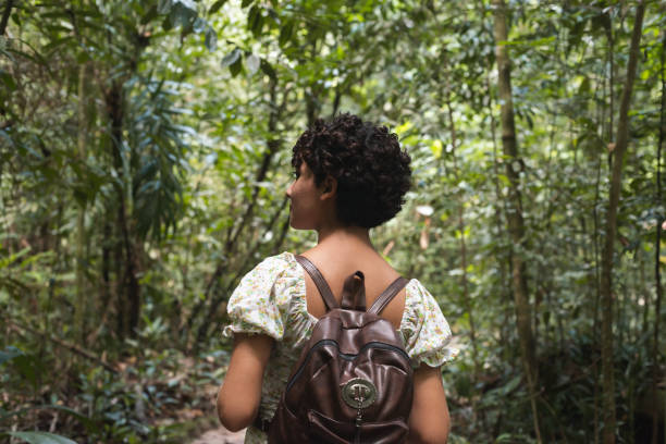 istock Young woman walking alone in the forest 1433945087