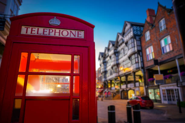 Chester Bridge Street at sunset with red telephone box in England UK Chester Bridge Street at sunset with red telephone box in England UK United Kingdom chester england stock pictures, royalty-free photos & images