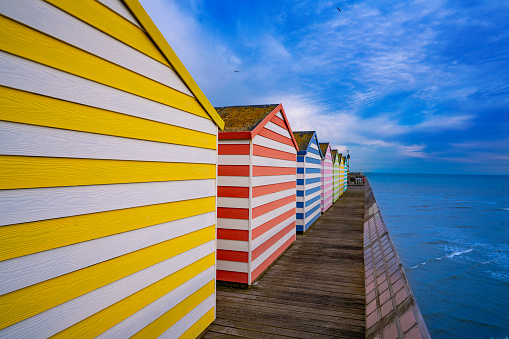 Hastings pier with colorful striped huts resort town in East Sussex England UK United Kingdom