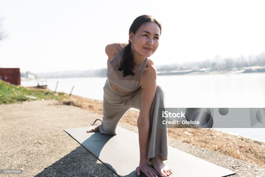 Woman having a yoga class by the river Woman doing yoga by the river 35-39 Years Stock Photo