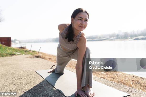 Woman Having A Yoga Class By The River Stock Photo - Download Image Now - 35-39 Years, Active Lifestyle, Adult