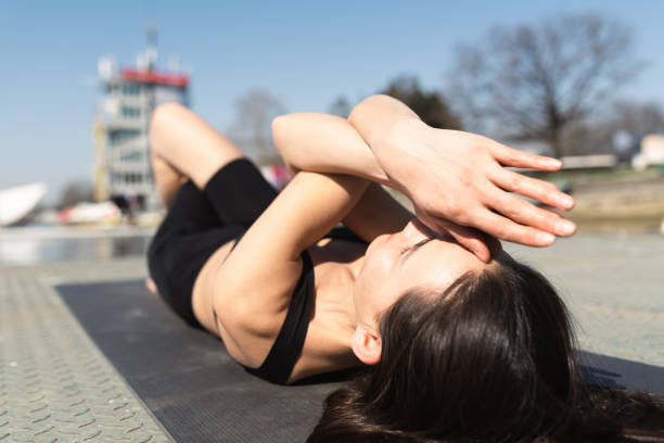 istock Woman lying down and doing yoga by the river 1433971953