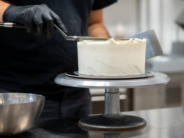 istock chef smoothing a forsted cake with buttercream, spatula and wrench 1433972285