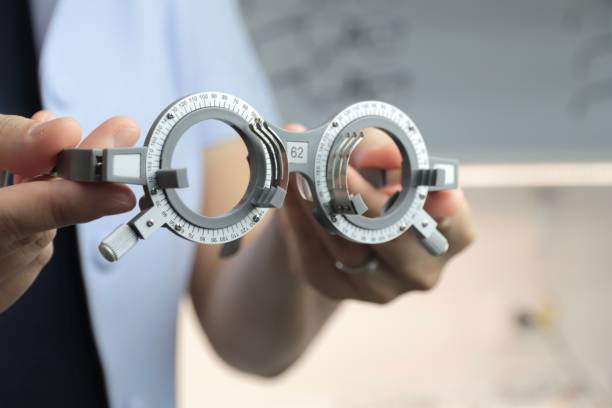 istock Hand holding trial frame, eyeglasses frame test, holding eyeglasses in optical shop 1433999342