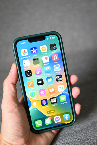 iPhone with iOS 16 logo on home screen, close up new operating system 2022-2023 on iPhone apple devices version ios 16 screen display man hand holding iPhone : Bangkok, Thailand - September 2022