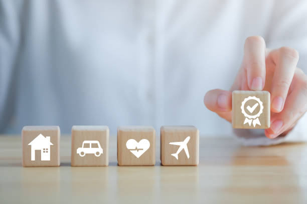 istock Insurance concept. Protection against a possible eventuality. Hand holding quality assurance with House, Car, healthcare and travel icon on wood block for Warranty security and assurance life concept. 1434017654