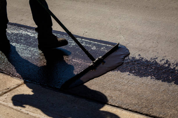 Worker using a sealcoating brush during asphalt resurfacing project Worker using a sealcoating brush during asphalt resurfacing project tar stock pictures, royalty-free photos & images