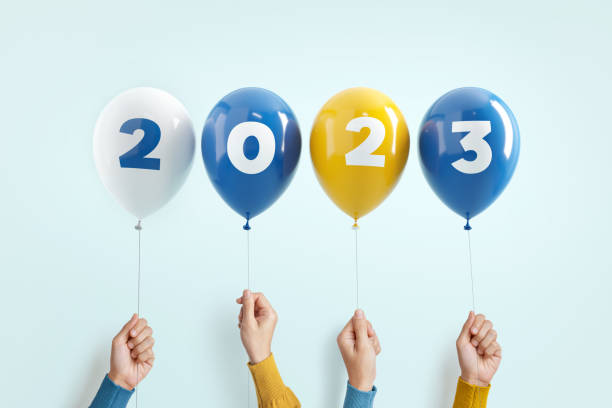 New year number 2023 of balloons in hands on blue background. stock photo