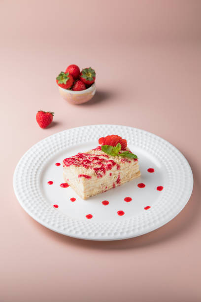 istock white plate and cake, Slice of plain cheesecake on white plate. with Cream Puffs Eclairs 1434026018