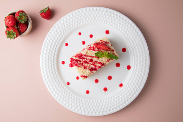 istock white plate and cake, Slice of plain cheesecake on white plate. with Cream Puffs Eclairs 1434026039