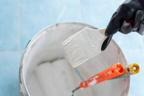 istock Paint brush and paint roller in white paint bucket. 1434028400