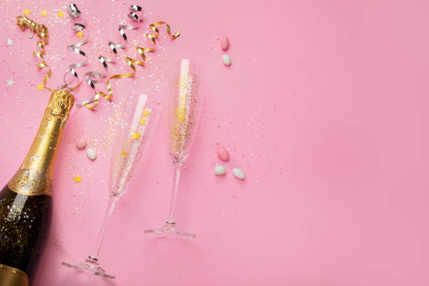 istock Champagne bottle with confetti on pink background. 1434029798