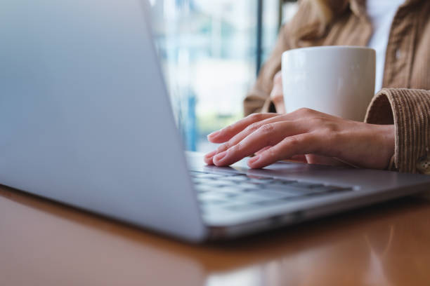 istock Closeup image of a woman using and working on laptop computer while drinking coffee 1434031130