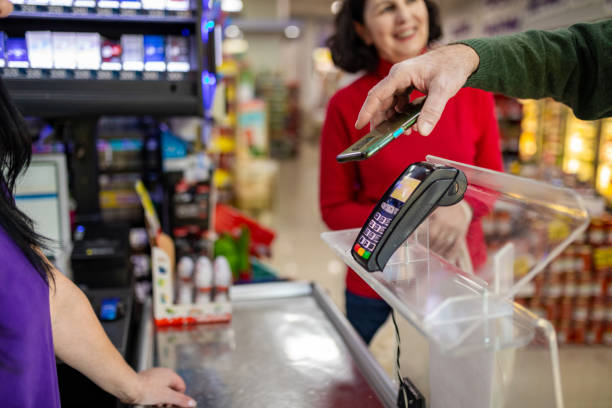 istock Mature man paying with smartphone in supermarket 1434037913