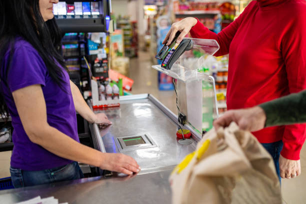 istock Woman paying with smartphone in supermarket 1434038749