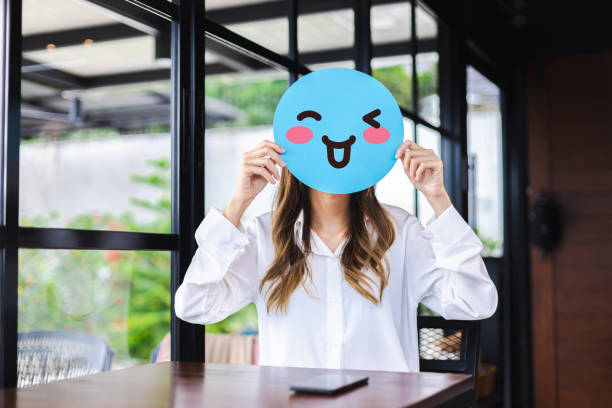 Customer experience review and feedback satisfaction service concept. Woman holding happy face emoji for giving good feedback rating