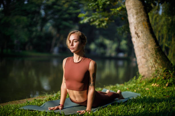 Beautiful blond girl doing morning yoga at the park stock photo