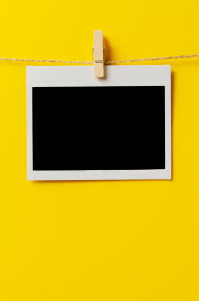 istock An empty photo is hanging on a rope with a clothespin. A design element. Yellow background. Copy space. 1434049715