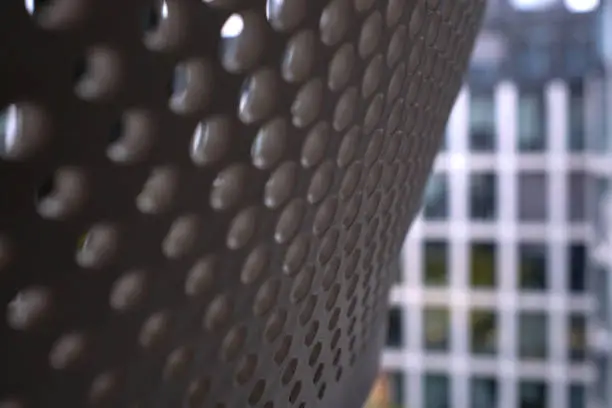 Photo of Detail of office chair back rest with a view of opposite office building in the background