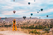 istock Traveler backpacker girl is watching hot air balloons and the fairy chimneys  at Cappadocia Goreme in Nevsehir , Turkey 1434054606
