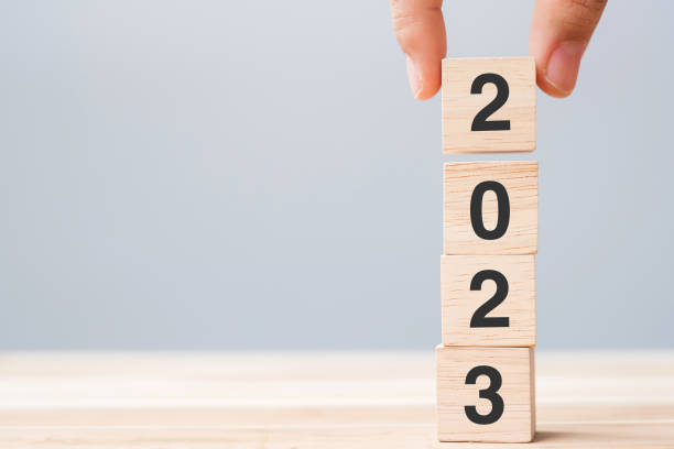 istock hand holding wooden cube block with 2023 text on table background. Resolution, plan, review, goal, start and New Year holiday concepts 1434055296