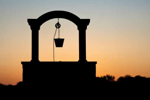 silhouette of a well at sunset.