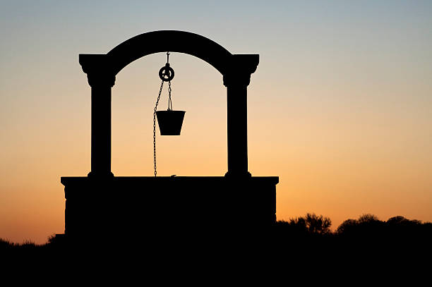 silhouette of a well silhouette of a well at sunset. wells stock pictures, royalty-free photos & images