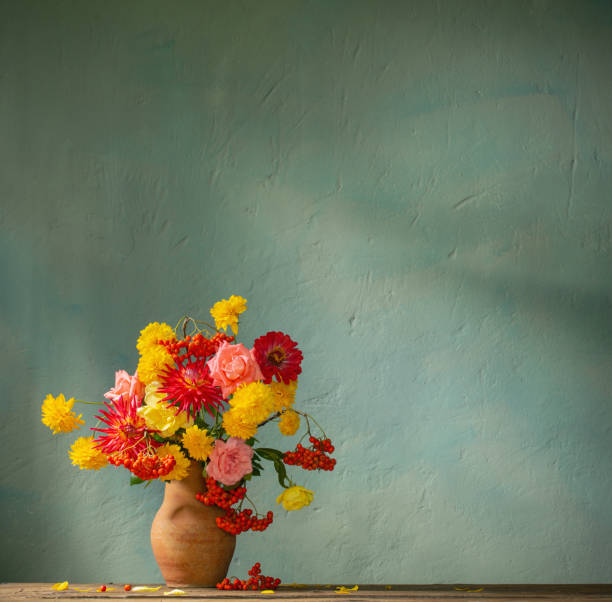 istock red and yellow flowers on jug in sunlight on background dark wall 1434057763