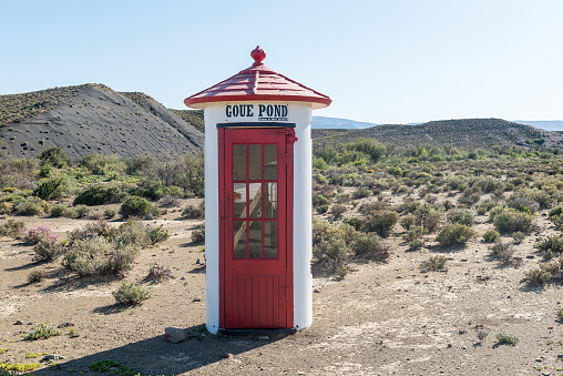 Sutherland, South Africa - Sep 4, 2022: A historic phone booth used as name board at the bottom of the Ouberg Pass near Sutherland in the Northern Cape Karoo